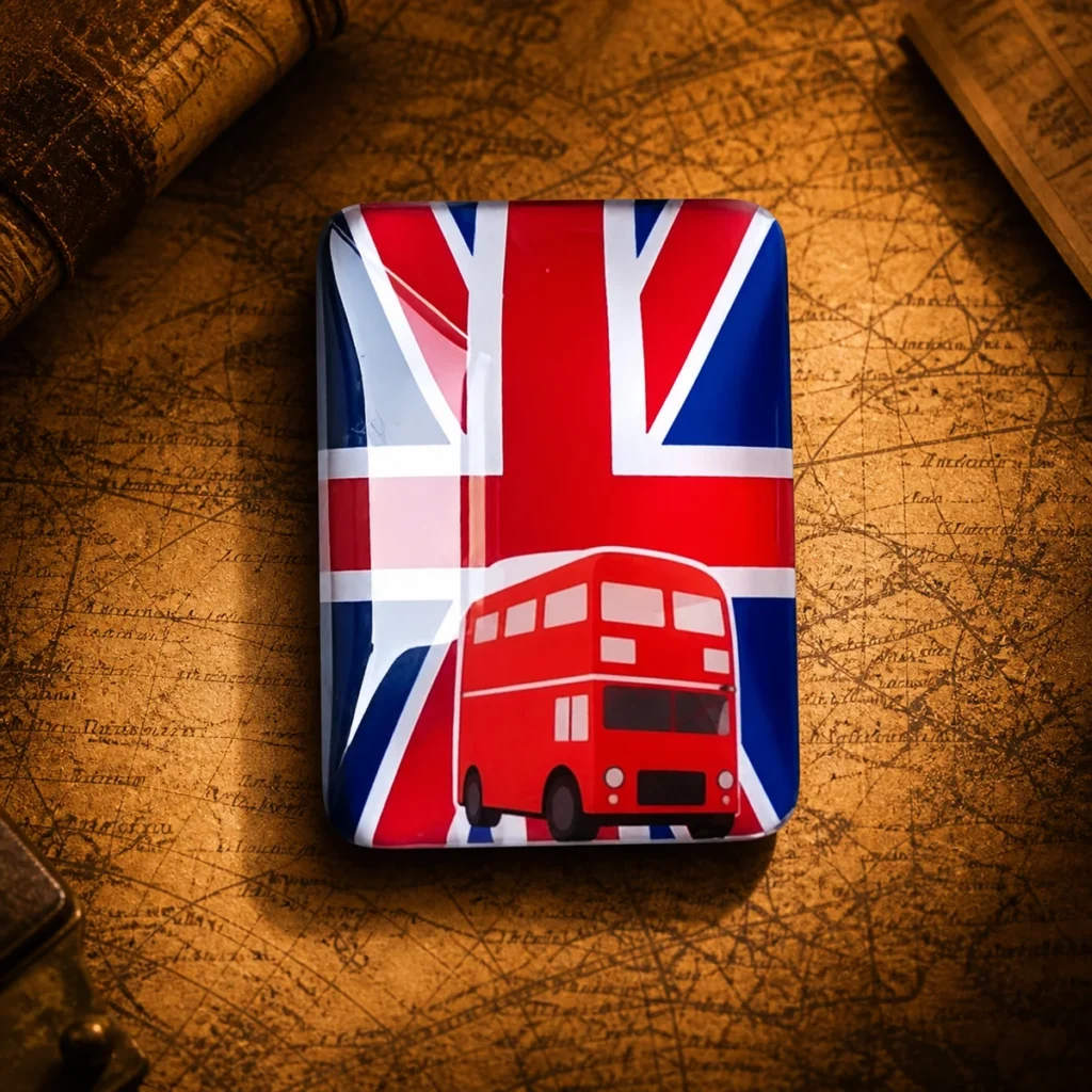 Custom glass UK flag and London bus souvenir fridge magnet on a dark travel map